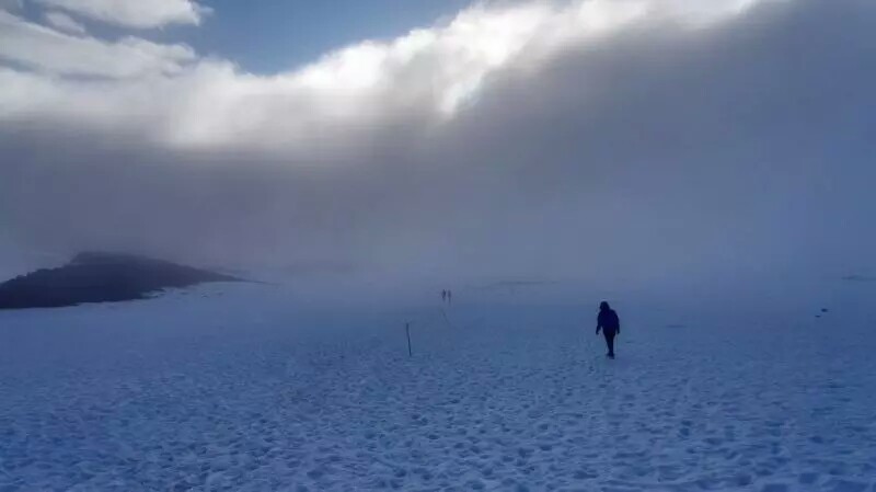 天气急转直下，已经有不少登山者沿途折返，风雪几乎把人冻住，前方的路看不
